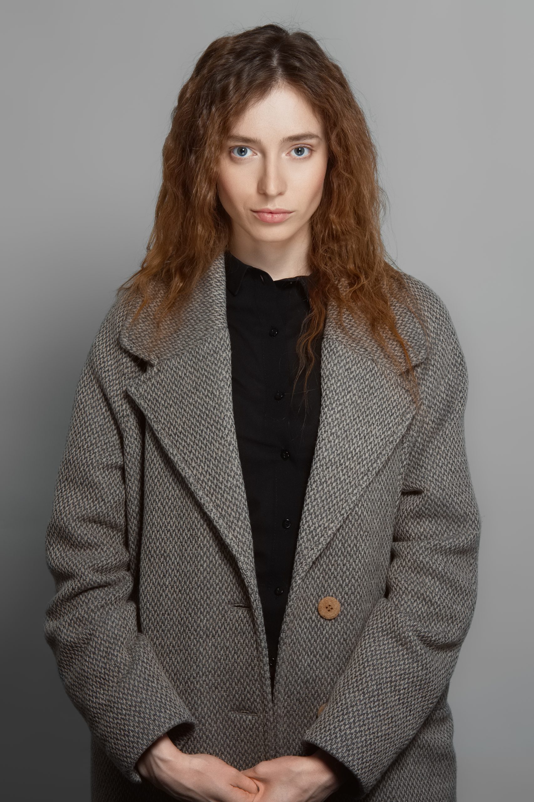 woman in houndstooth overcoat posing against gray 2026 03 17 00 01 12 utc